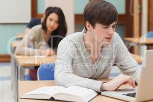 Student sitting at the classroom while typing