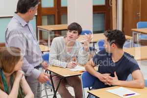 Students sitting talking to the teacher
