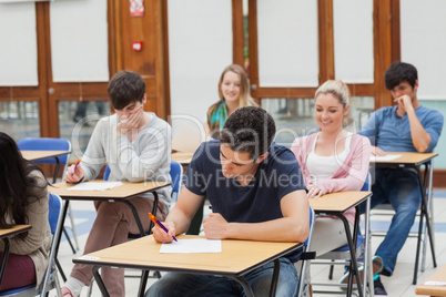 Students sitting at the exam room writing