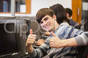 Man sitting at computer giving thumbs up