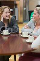 Women sitting at the coffee shop laughing
