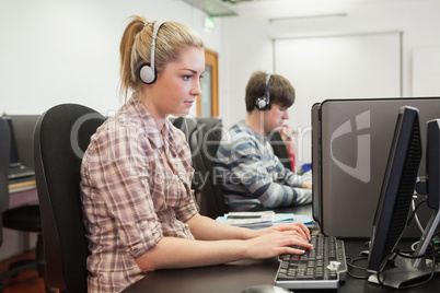 Student working in computer class wearing headphones