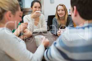 Students sitting at the table drinking coffee