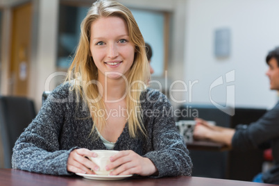 Woman sitting drinking a cup of coffee