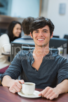 Man sitting at table drinking coffee