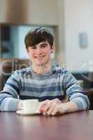 Man sitting at the table drinking coffee in college cafe