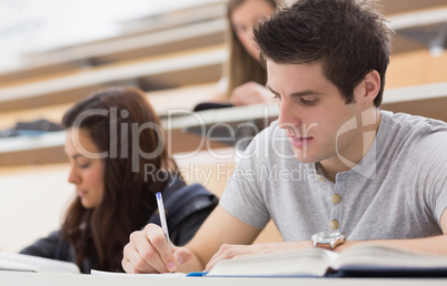 Students sitting at the lecture hall while writing