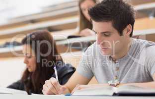 Students sitting at the lecture hall while writing