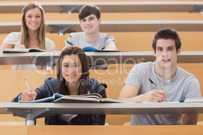 Students sitting at the desk while smiling