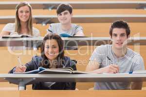 Students sitting at the desk while smiling