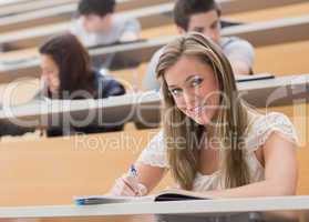 Woman sitting at the lecture hall while smiling