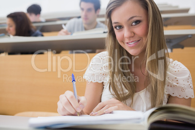 Woman sitting at the lecture hall while writing