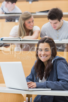 Girl sitting at the lecture hall with laptop