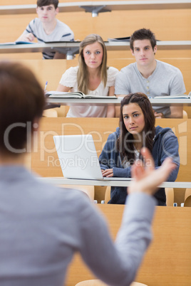 Students sitting at the lecture hall listening