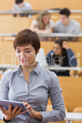 Teacher standing holding a tablet computer