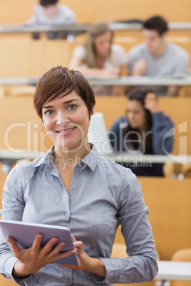 Woman standing holding a tablet computer smiling