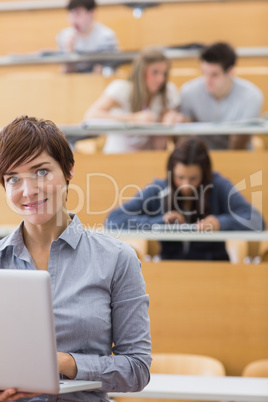 Teacher standing holding a laptop