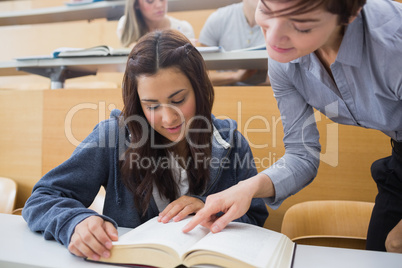 Teacher and student looking at a book