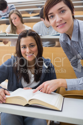 Smiling student and lecturer with book