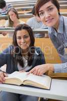 Smiling student and lecturer with book