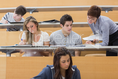 Students sitting at the lecture hall while teacher explaining