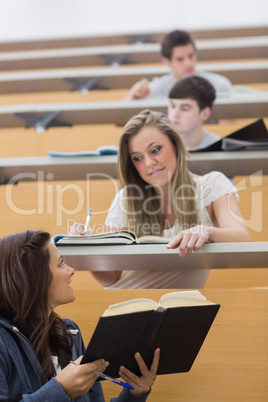 Student showing friend a book