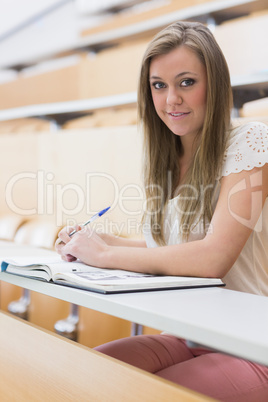 Girl sitting at the lecture hall while writing