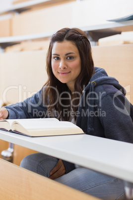 Woman sitting at the lecture hall reading