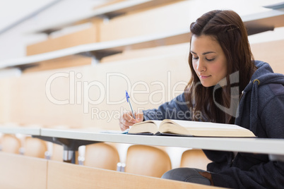 Girl reading a book and writing notes