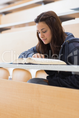 Girl reading a book at the lecture hall