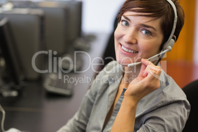 Teacher sitting at the computer room wearing headset