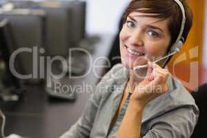 Teacher sitting at the computer room wearing headset