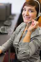 Teacher sitting at the computer room wearing a headset