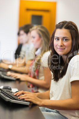 Woman sitting at the computer while smiling in college