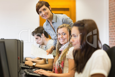 Student and teacher smiling at the computer room