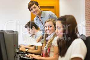 Student and teacher smiling at the computer room