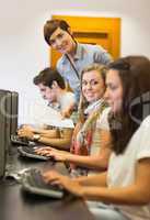 Students sitting at the computer teacher smiling