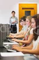 Teacher standing holding paper in computer room