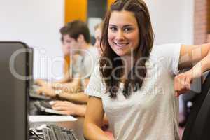 Student sitting at the computer room smiling