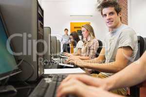 Students sitting at the computer room with man smiling