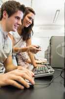Students sitting at the computer with woman pointing at screen