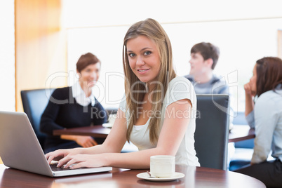 Woman sitting at the coffee shop at table using laptop