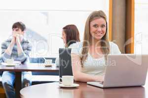 Girl sitting at the college coffee shop with laptop