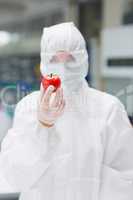 Woman wearing protective suit holding a tomato