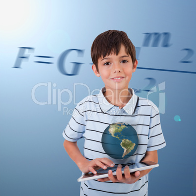 Little boy holding a tablet with a holographic globe hovering ov