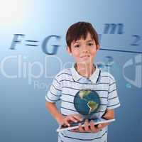 Little boy holding a tablet with a holographic globe hovering ov