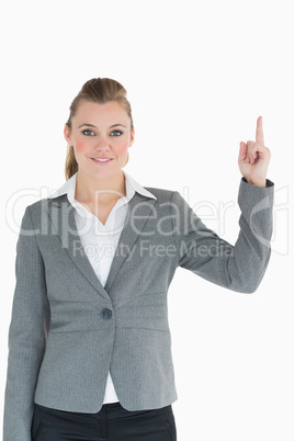 Smiling businesswoman pointing up in the air