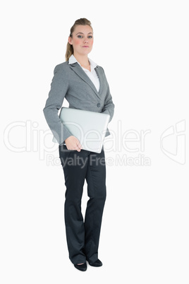 Serious businesswoman holding laptop