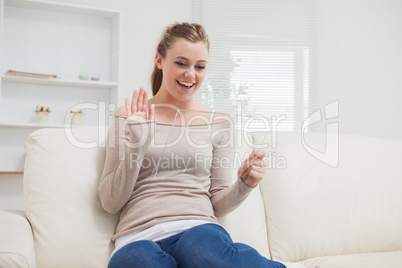 Woman waving at clear pane on the sofa