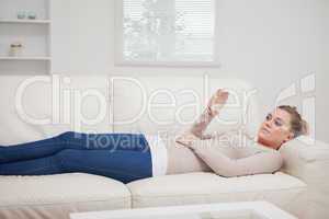 Woman lying on the sofa while viewing a pane